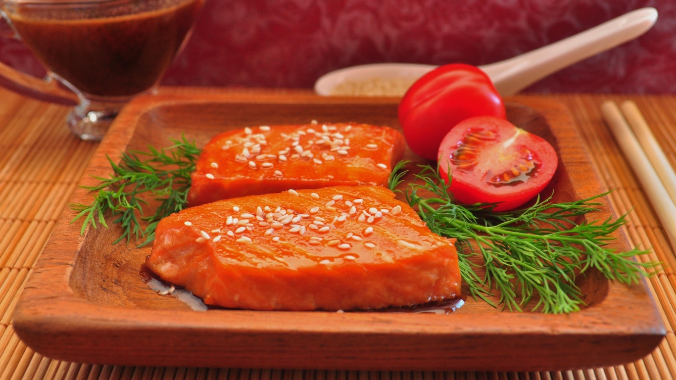 Красная рыба с кунжутом на тарелке с помидорами и укропом