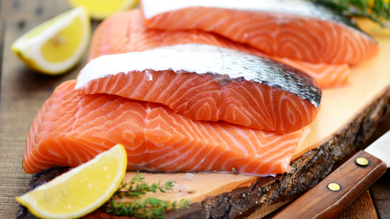 Кусочки красной рыбы с лимоном на столе