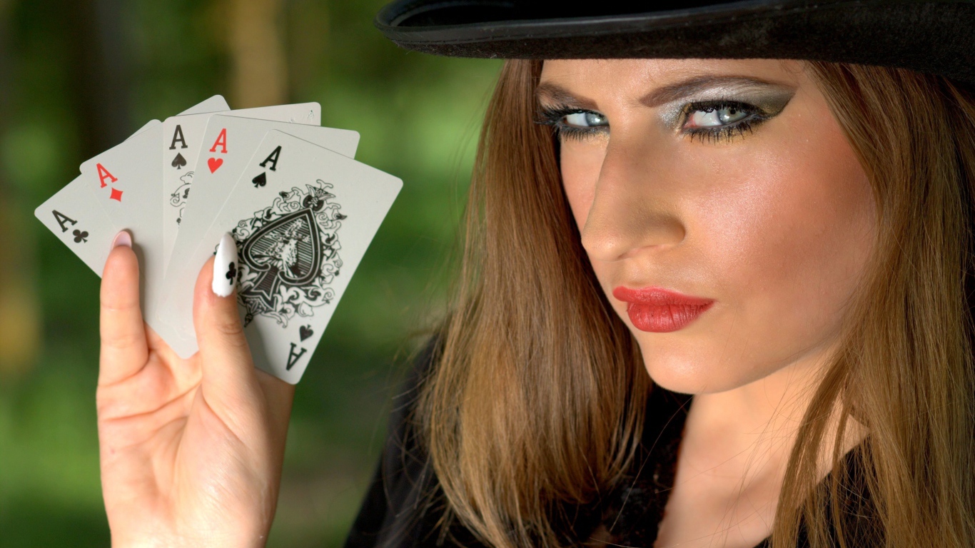 Девушка в черной шляпе с четырьмя тузами в руке