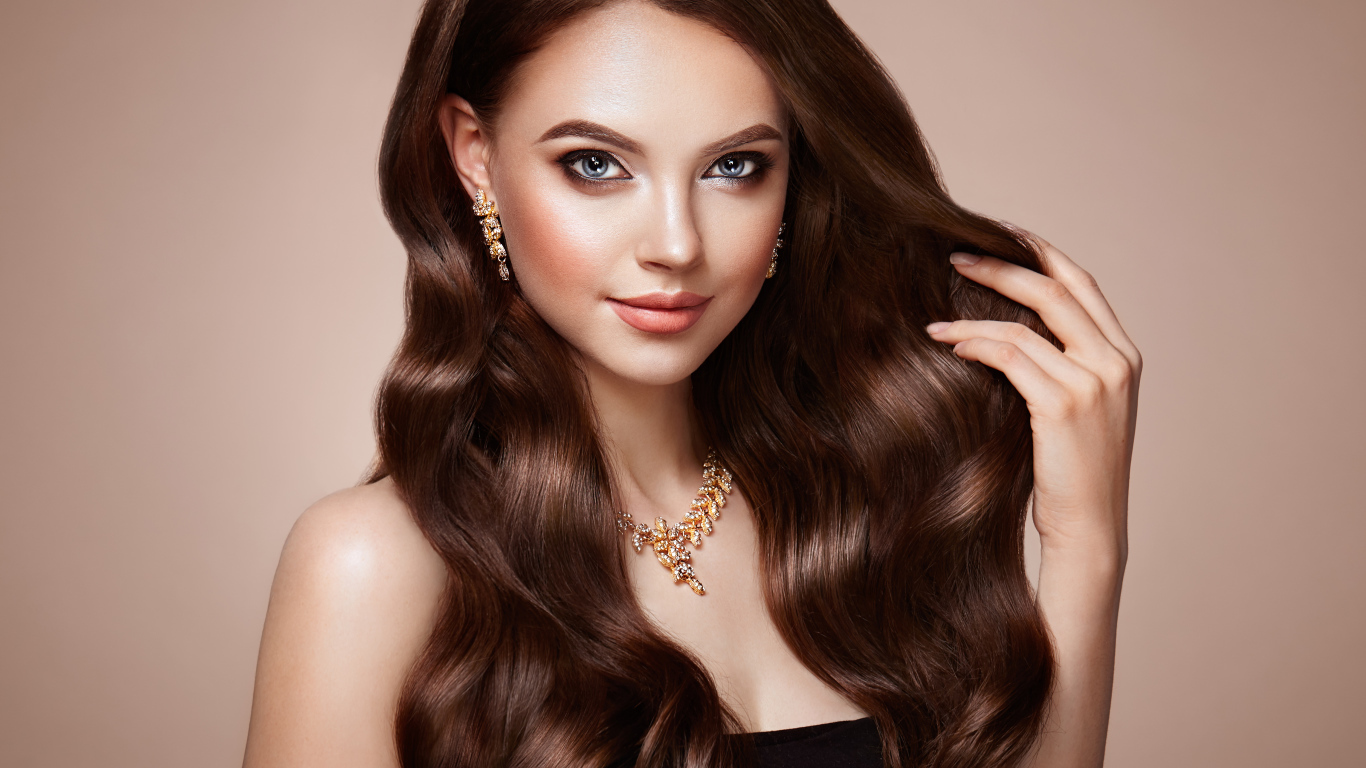 Красивая голубоглазая длинноволосая девушка шатенка с золотым украшением на шее 