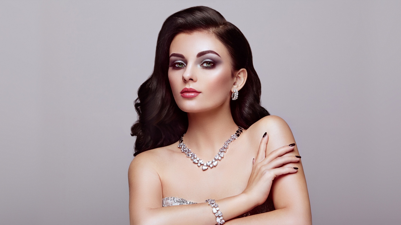 Красивая яркая брюнетка на сером фоне