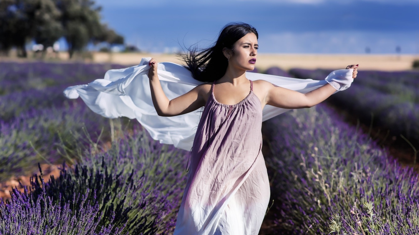 Красивая брюнетка в сарафане гуляет по лавандовому полю