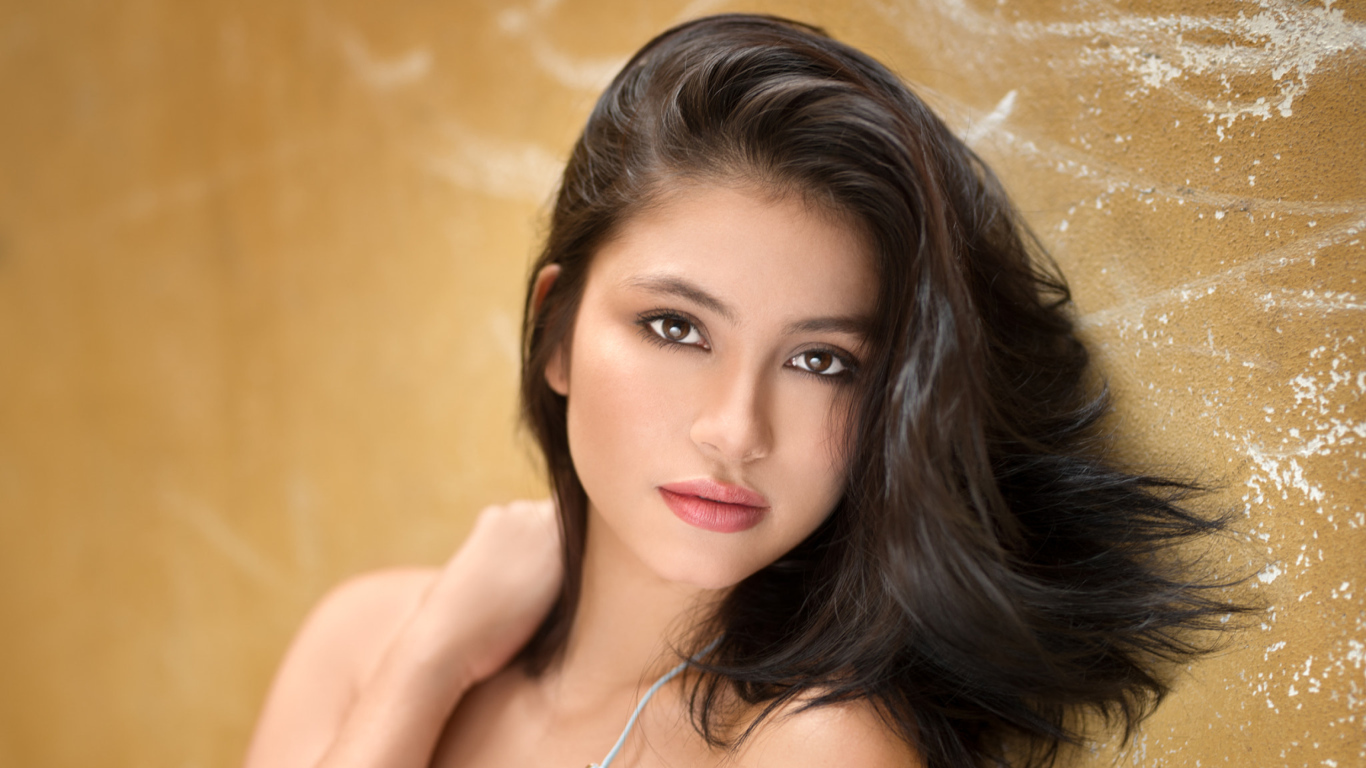 Красивая брюнетка на фоне стены 