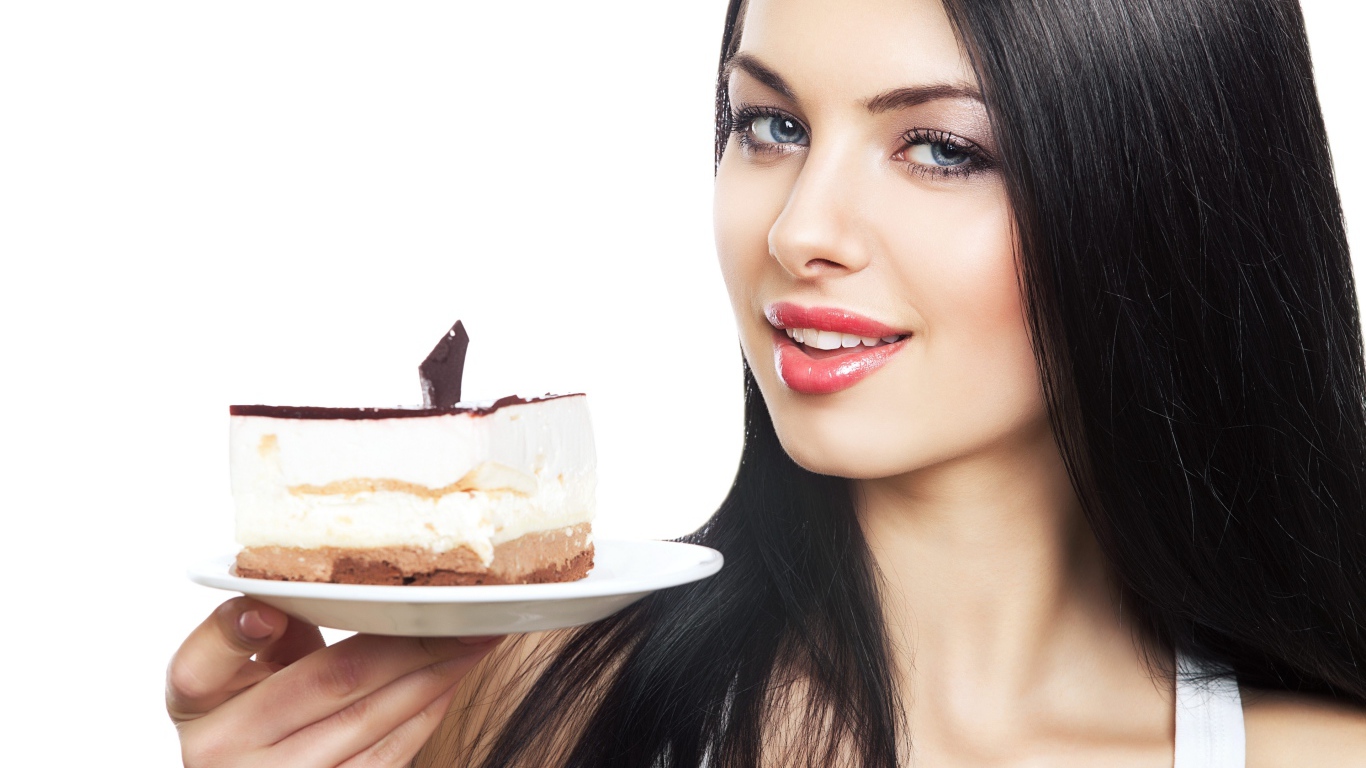 Красивая брюнетка с куском торта на блюдце