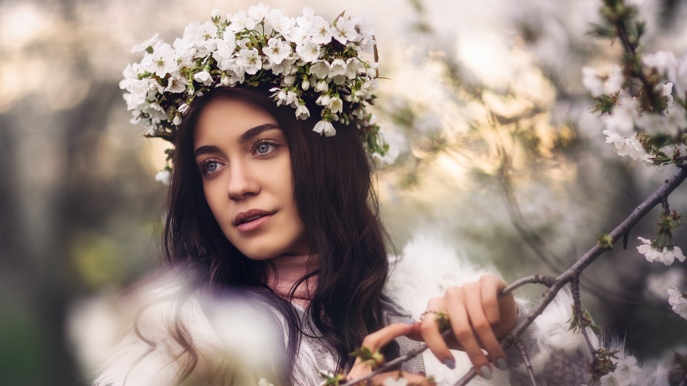 Красивая брюнетка с венком из цветов вишни на голове