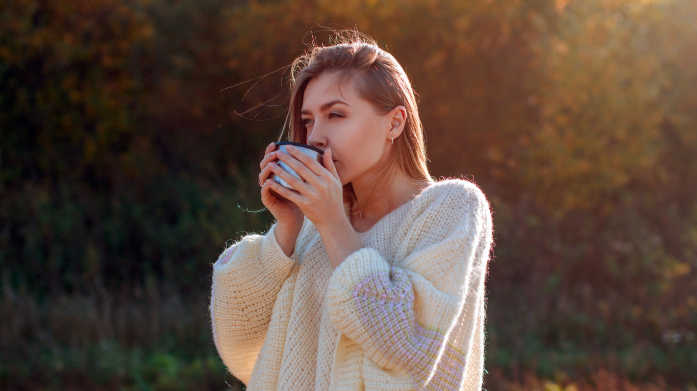 Красивая девушка пьет чай в теплом свитере