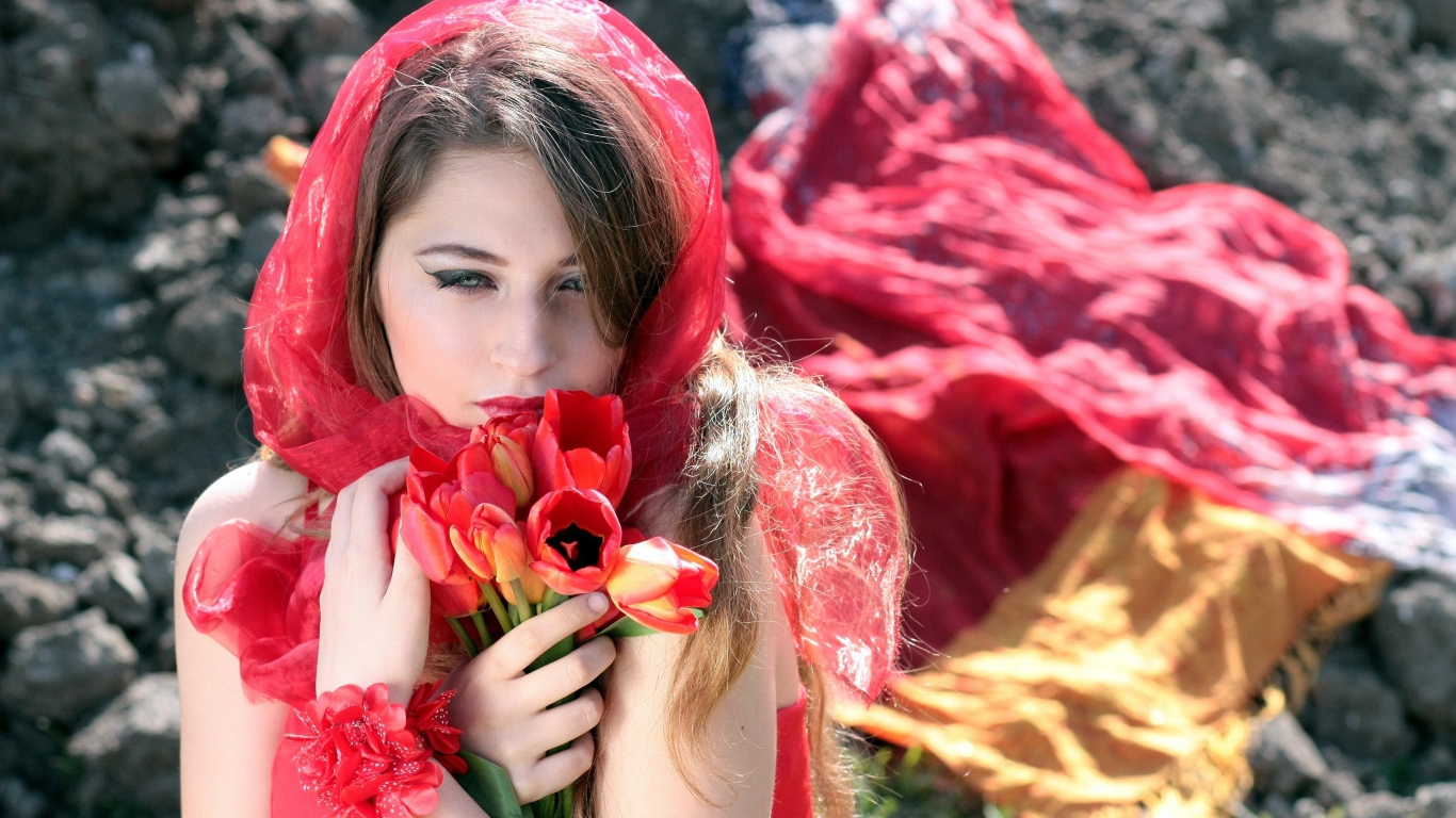 Красивая девушка в красной шали с букетом тюльпанов