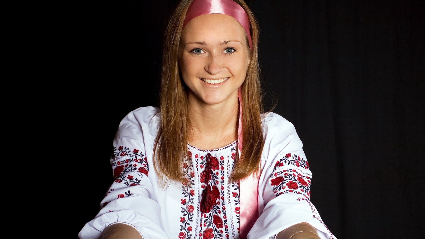 Красивая девушка в вышитой рубашке на черном фоне