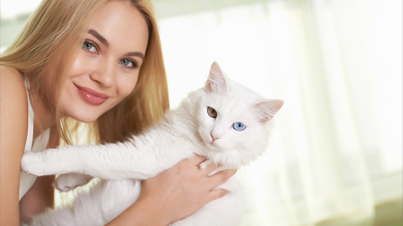 Красивая девушка с белым котом в руках