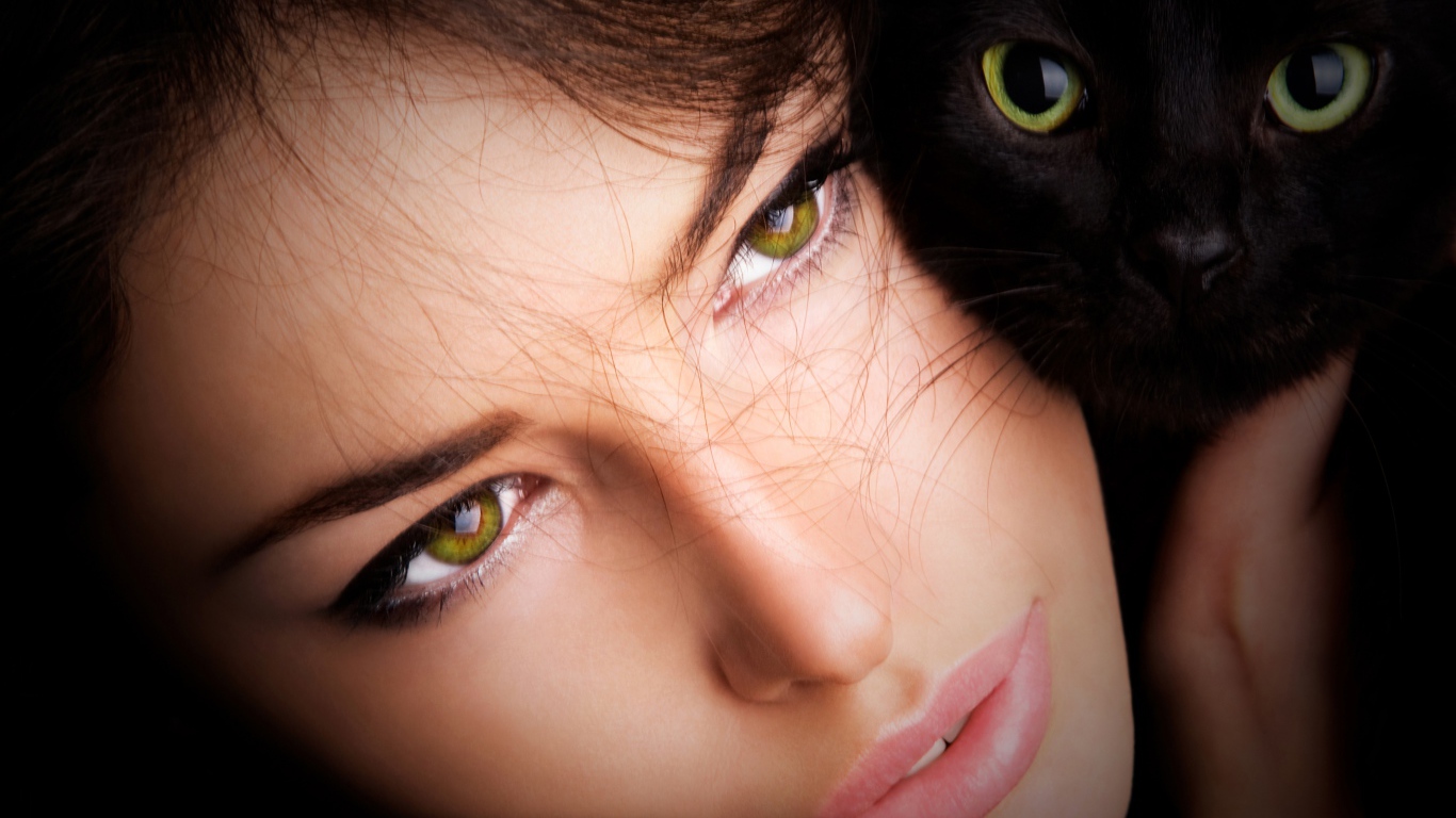 Красивая зеленоглазая девушка с черной кошкой