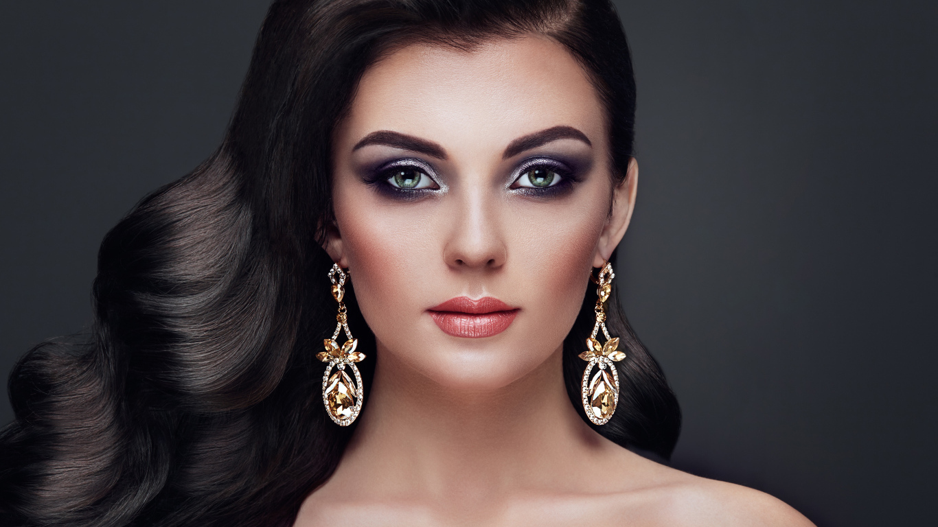 Красивая длинноволосая девушка с ярким макияжем и длинными серьгами
