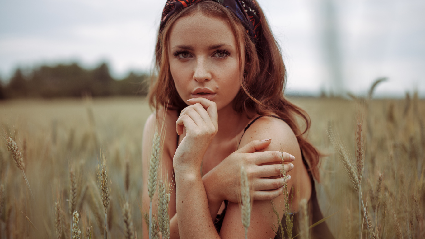 Красивая рыжеволосая девушка на поле с пшеницей