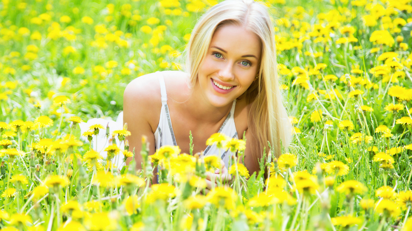 Красивая улыбающаяся блондинка в желтых одуванчиках