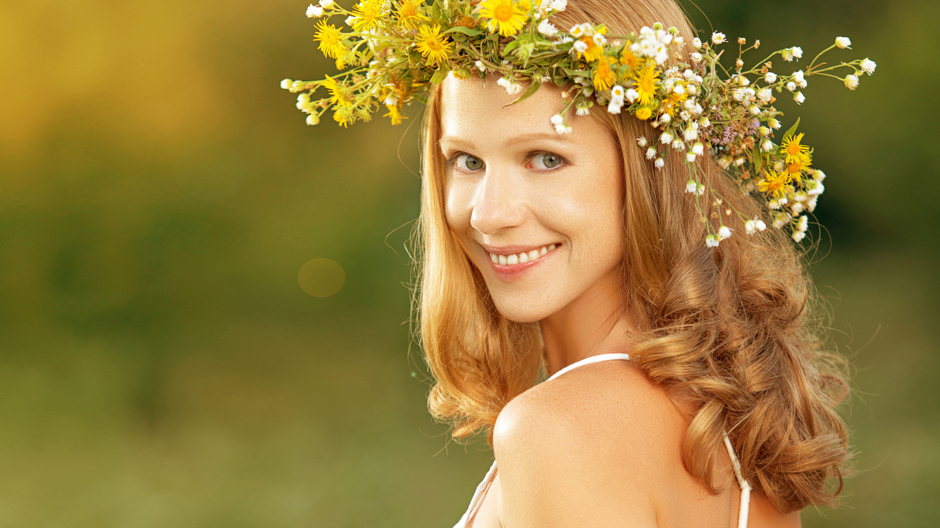 Красивая улыбающаяся девушка с венком из полевых цветов на голове