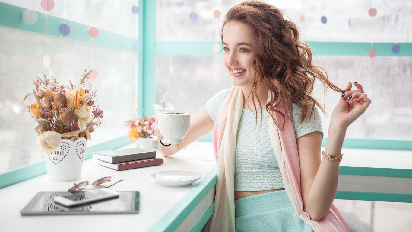 Красивая улыбающаяся девушка шатенка с чашкой кофе