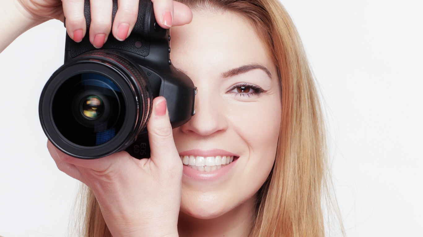 Красивая улыбающаяся девушка с фотоаппаратом