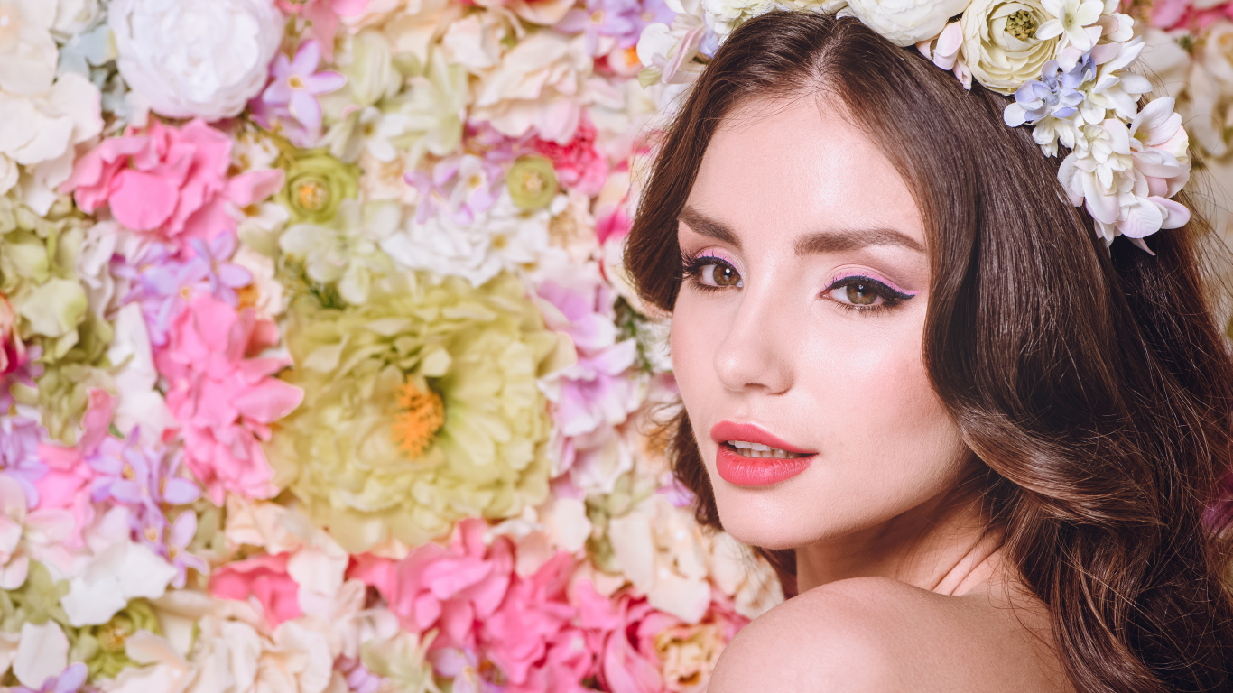 Красивая нежная девушка шатенка с венком на голове на фоне цветов