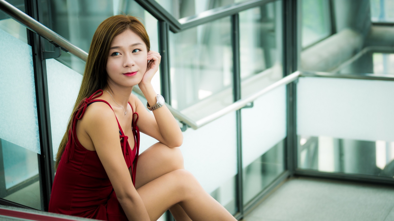 Красивая молодая девушка азиатка сидит на ступенях