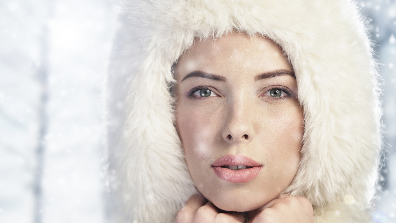 Красивая молодая девушка в белой зимней шапке 