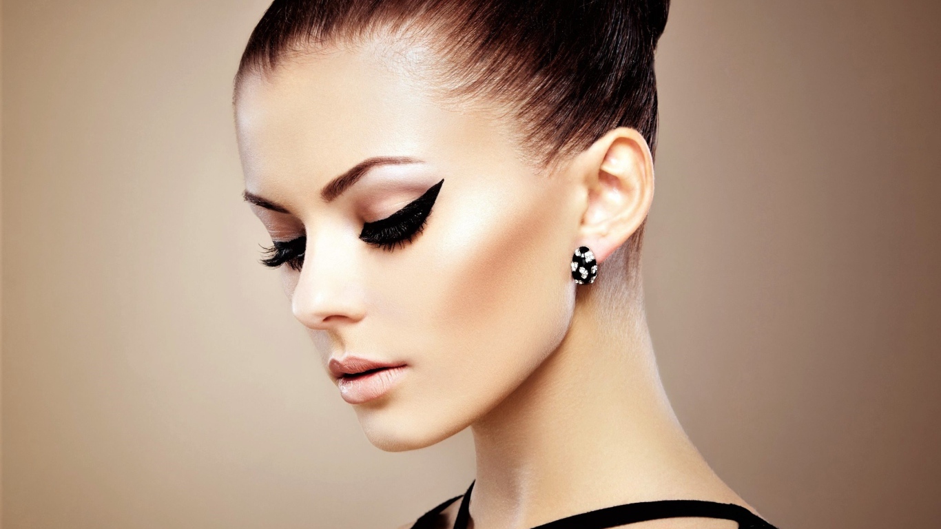 Красивая молодая девушка с макияжем и красивыми серьгами