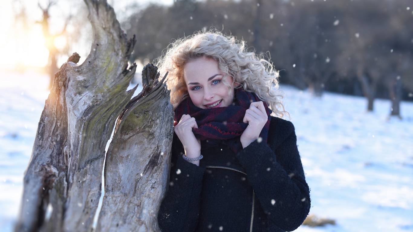 Голубоглазая блондинка у сухого дерева зимой