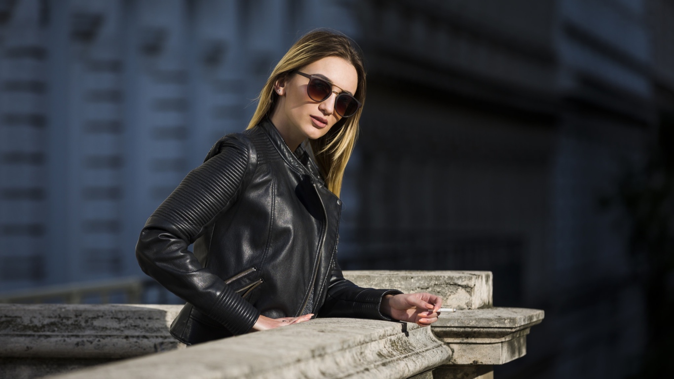 Дерзкая девушка в черной кожаной куртке и очках