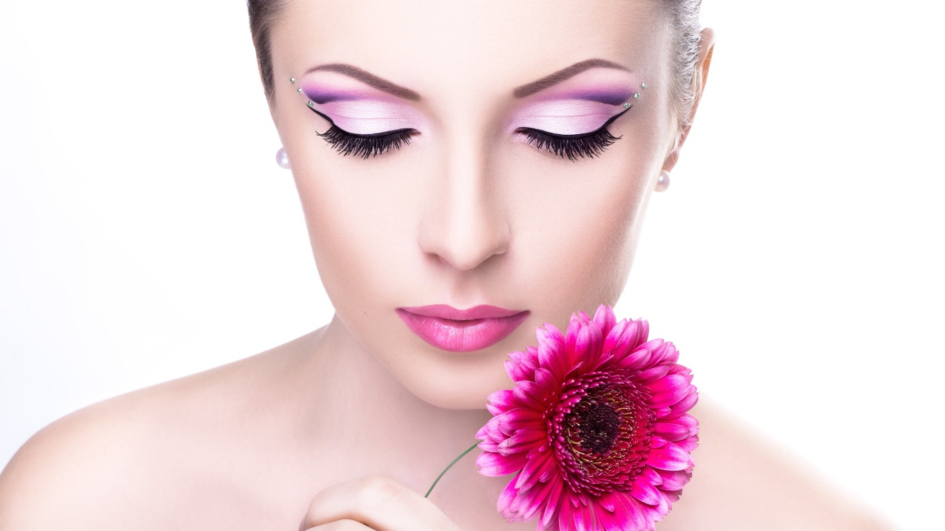 Нежная девушка с розовым цветком герберы на белом фоне