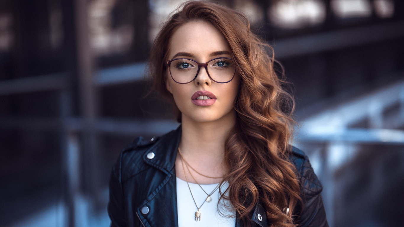 Девушка в черной куртке в очках 