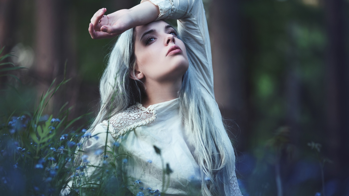 Грустная молодая блондинка в голубых цветах