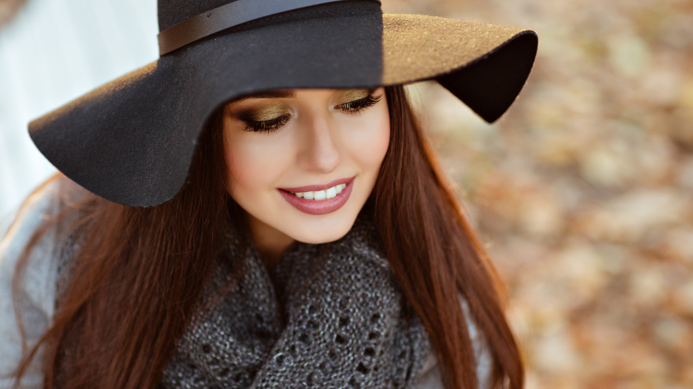 Улыбающаяся шатенка в большой черной шляпе