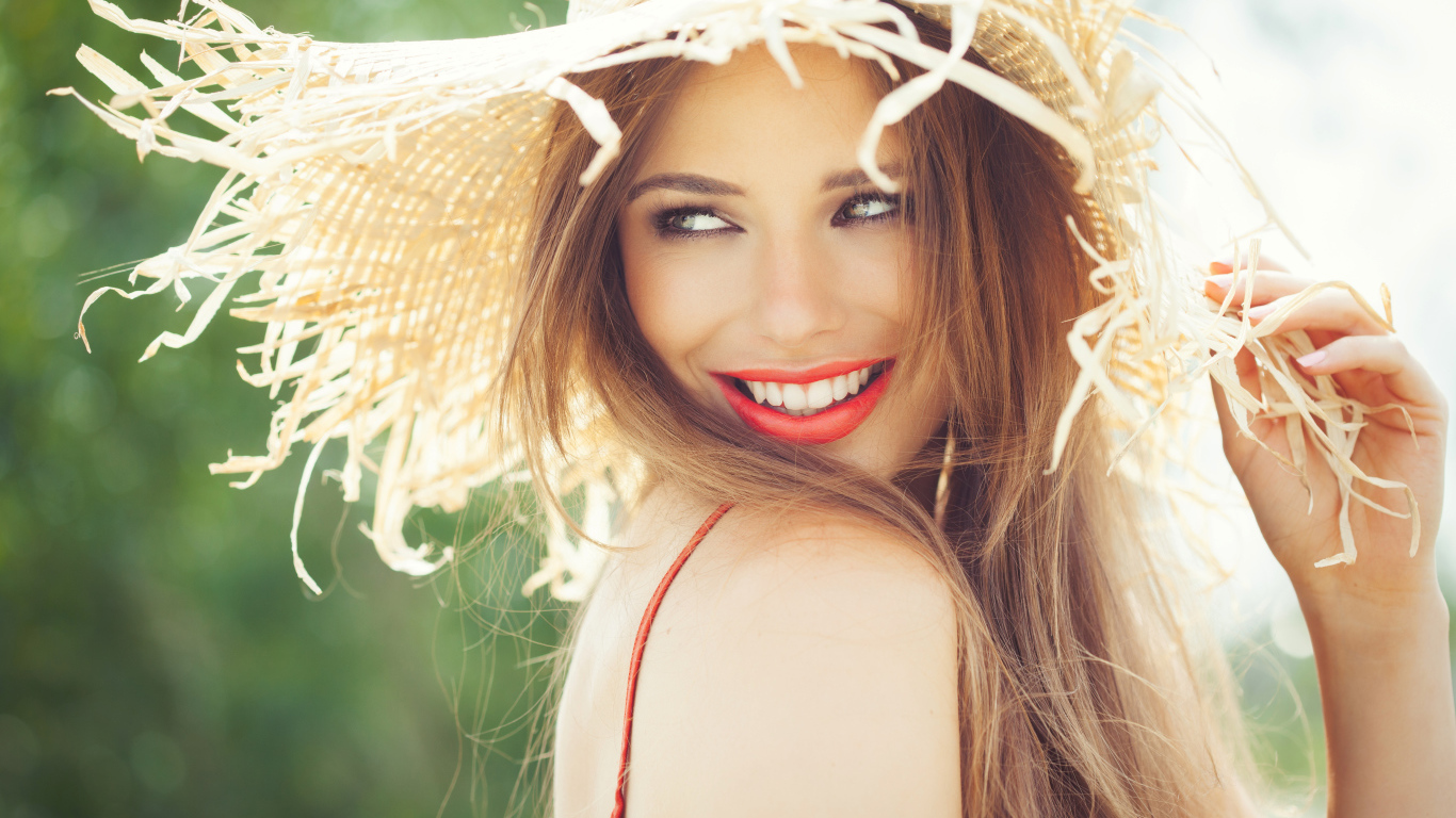 Улыбающаяся девушка в соломенной шляпе летом