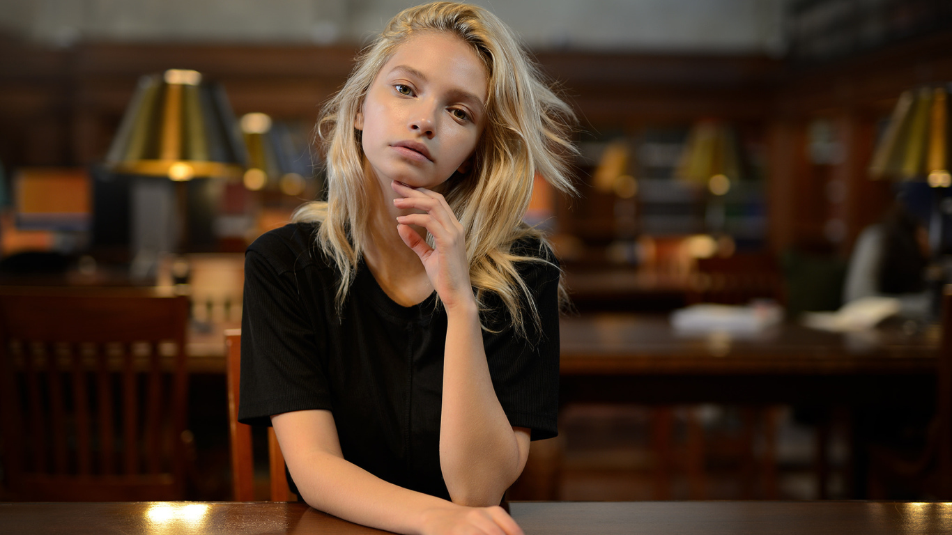 Нежная девушка блондинка в библиотеке