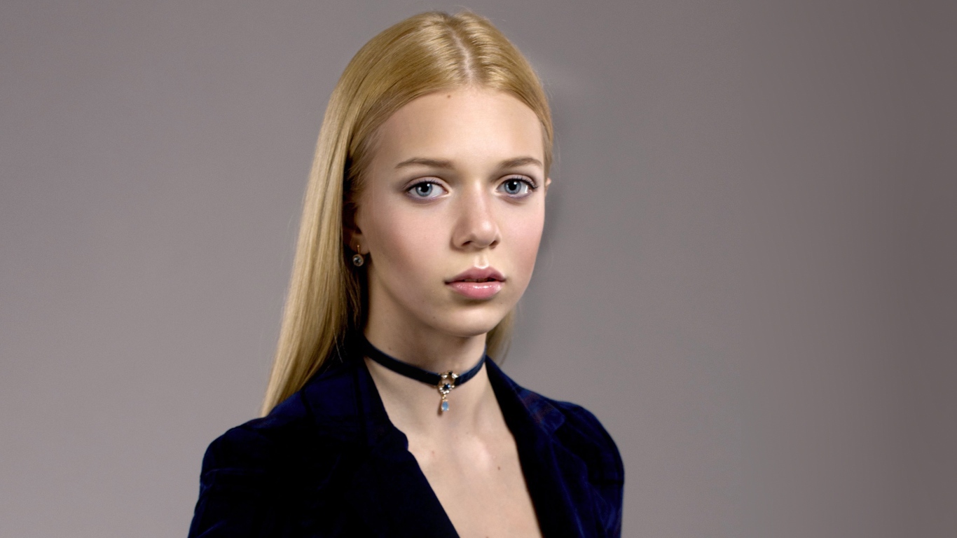 Нежная голубоглазая девушка с украшением на шее 