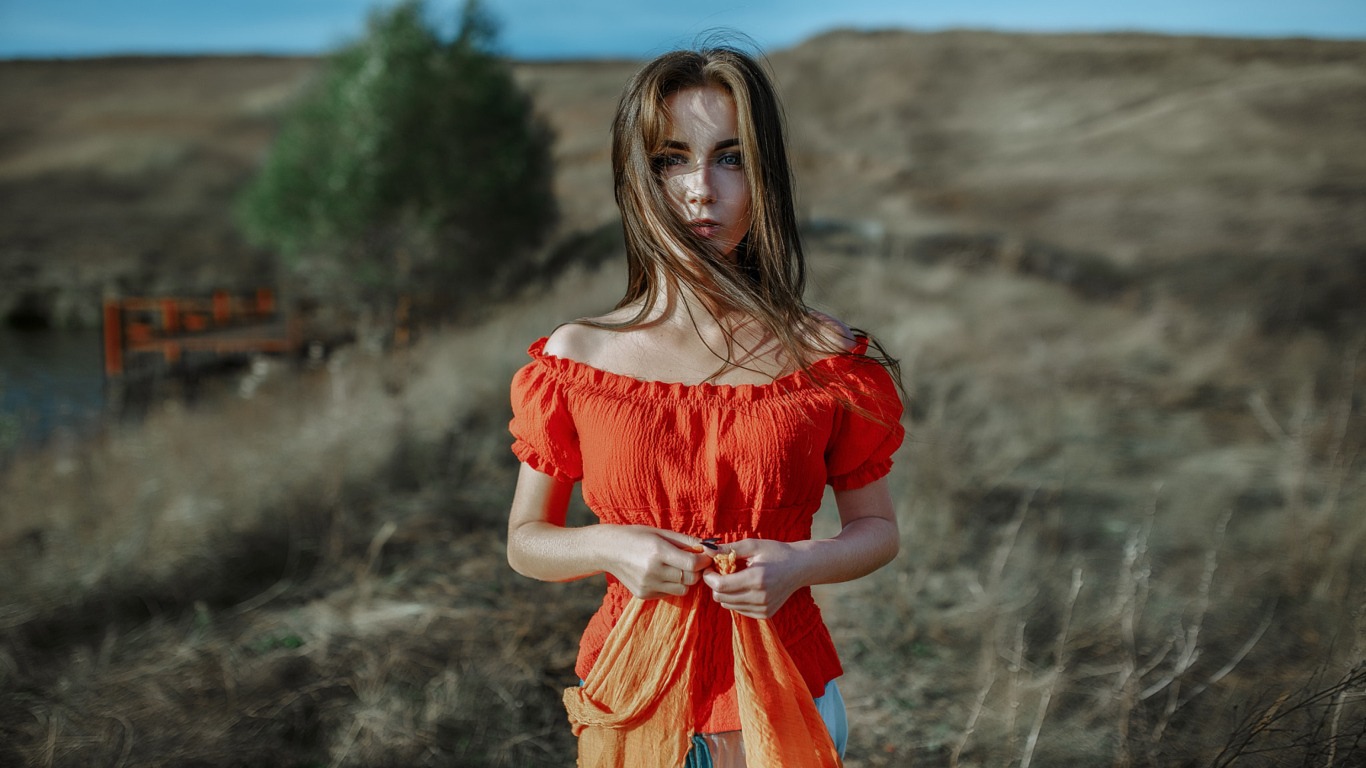 Ветер развивает волосы красивой девушке шатенке 