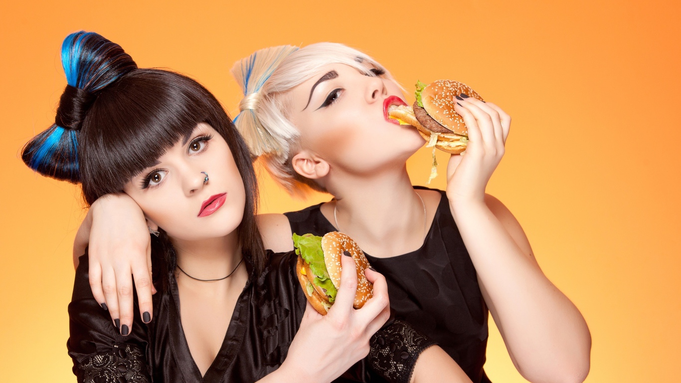 Две девушки с ярким макияжем с гамбургерами