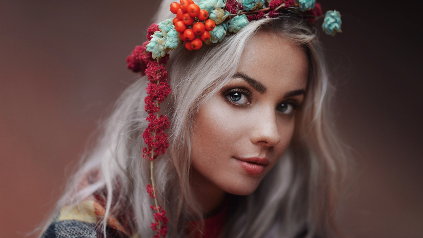 Молодая голубоглазая девушка с венком на голове