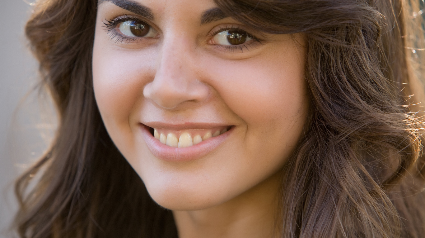 Молодая кареглазая брюнетка с очаровательной улыбкой