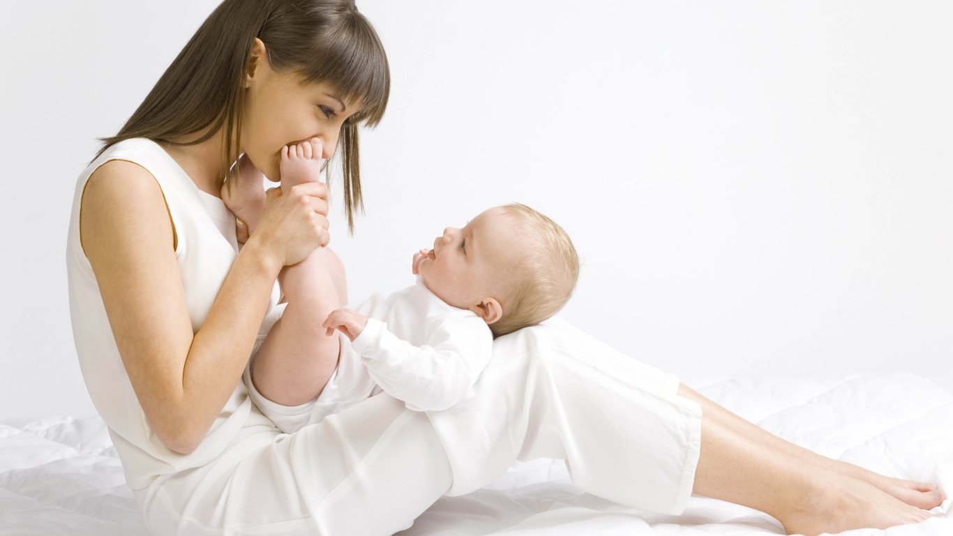 Молодая девушка в белом с младенцем