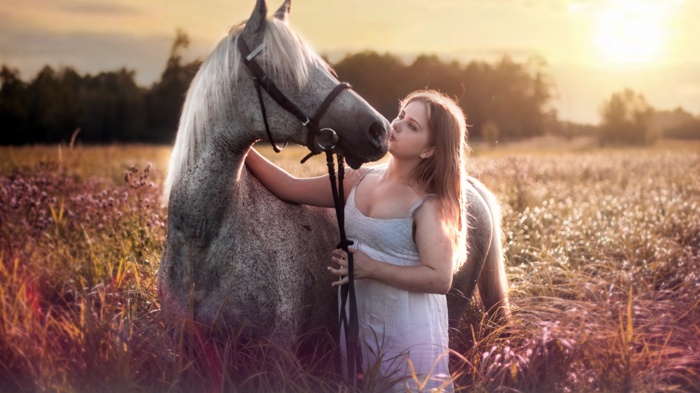 Молодая девушка с лошадью на поле