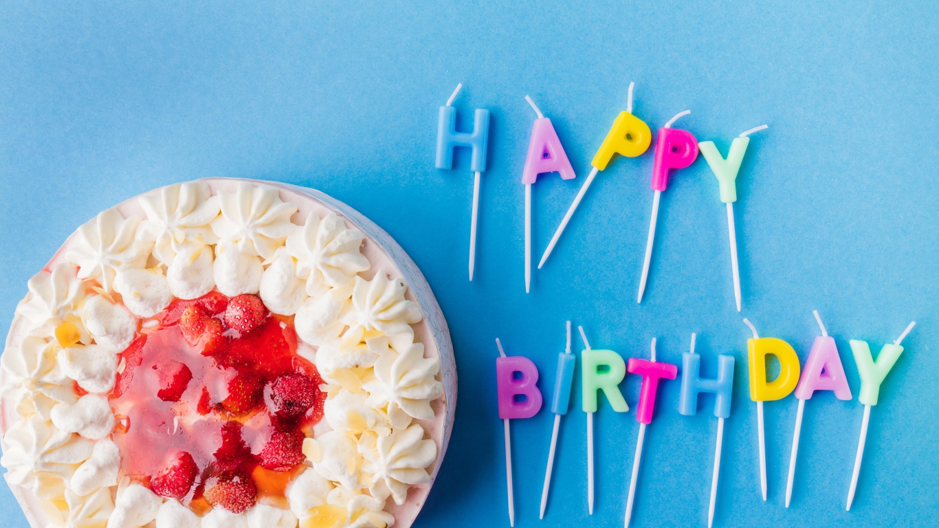 Красивый торт с кремом и клубникой на голубом фоне со свечами на день рождения