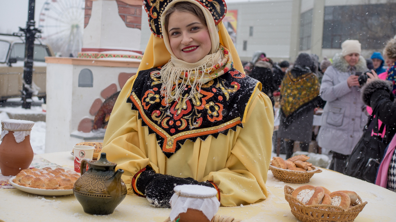 Красивая молодая девушка с угощениями на Масленицу 2018