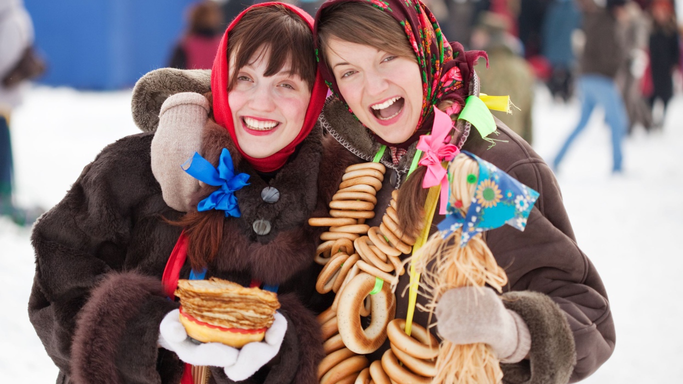 Две девушки с блинами и баранками на Масленицу