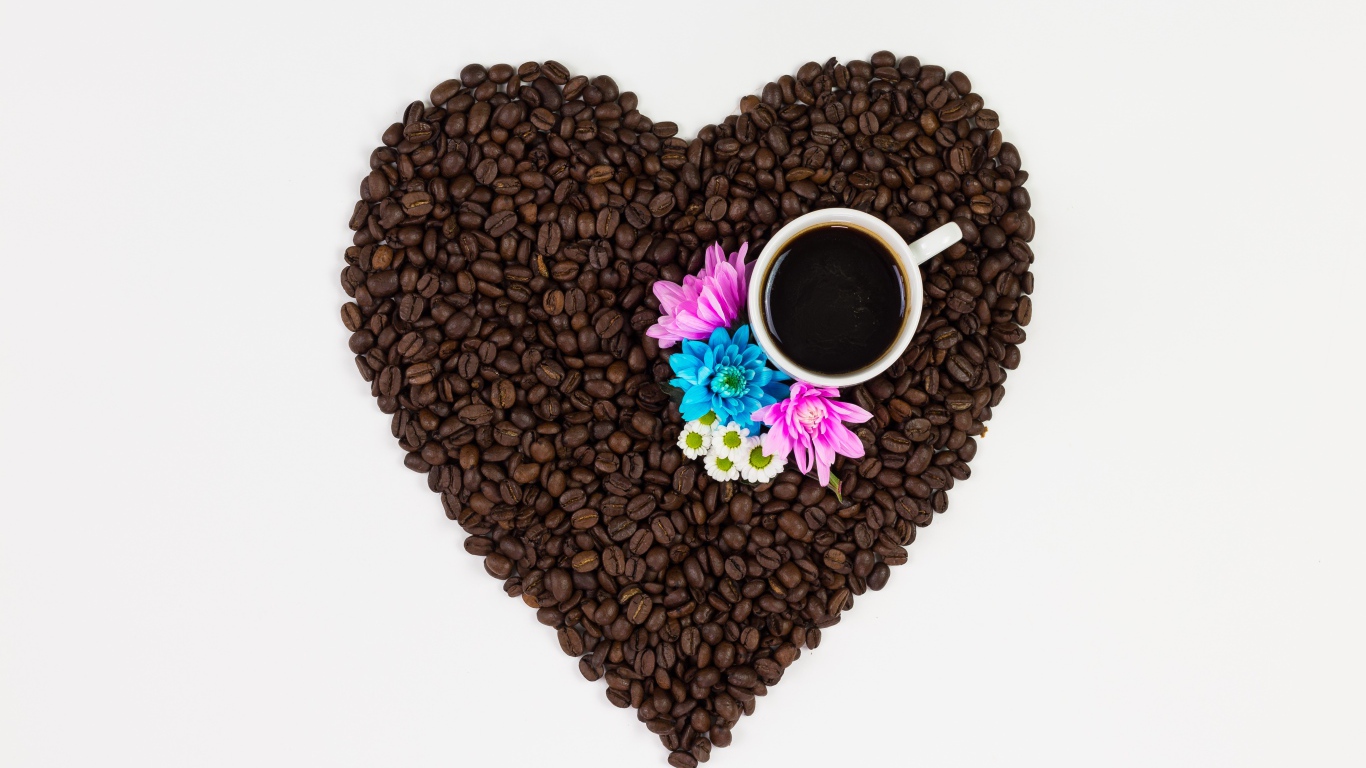 Сердце из кофейных зерен с чашкой на белом фоне