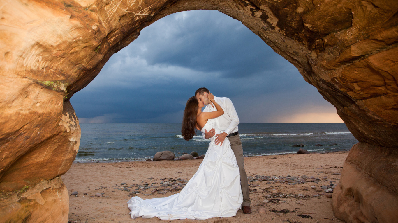 Поцелуй жениха и невесты на фоне моря