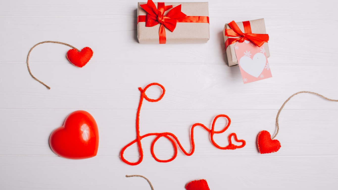 Надпись любовь красными нитями на сером фоне с сердечками и подарками