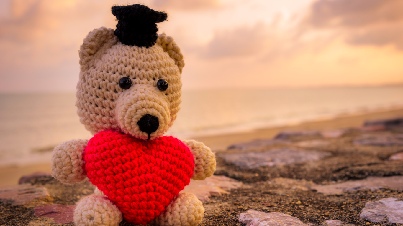 Toy bear with a red heart against the sky