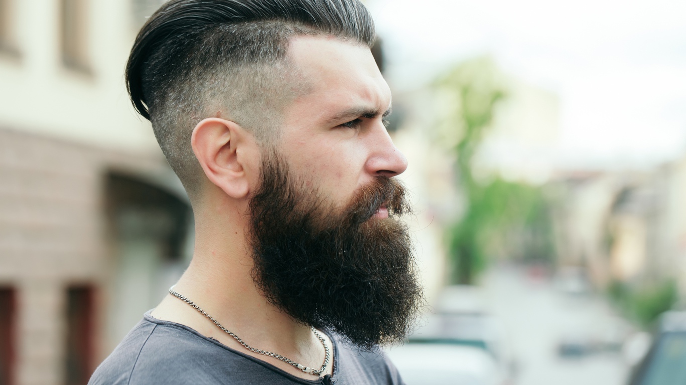 Стильный мужчина с бородой и прической на голове 