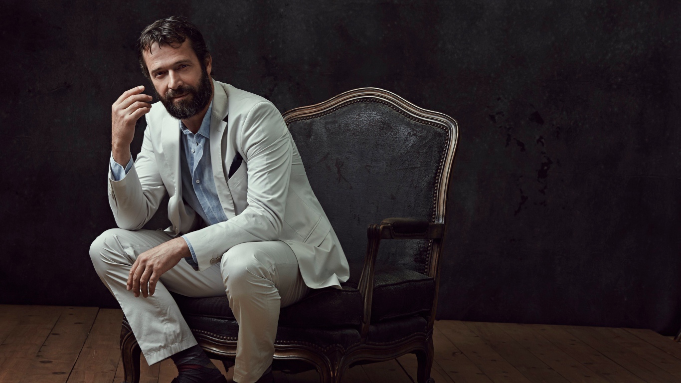 Актер Джеймс Пьюрфой сидит в кресле 