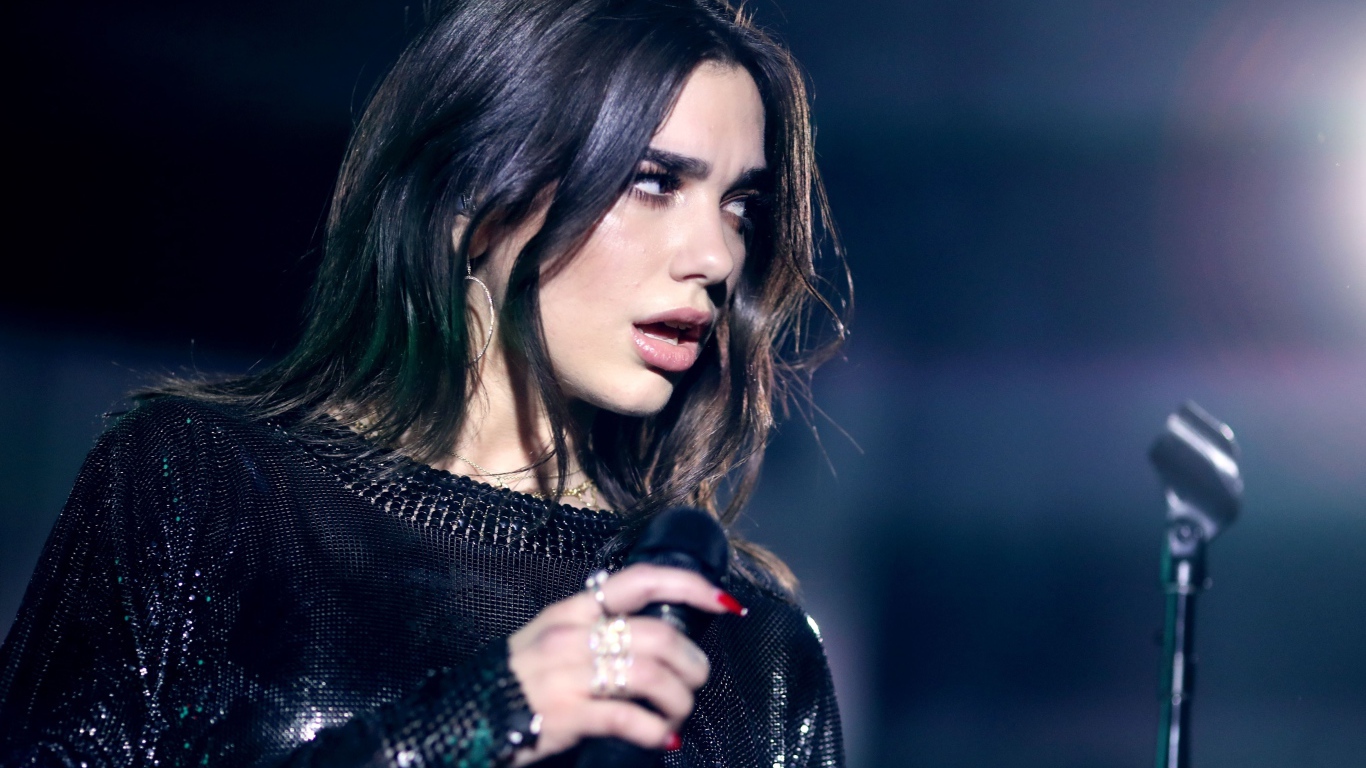 Британская певица Дуа Липа с микрофоном в руках