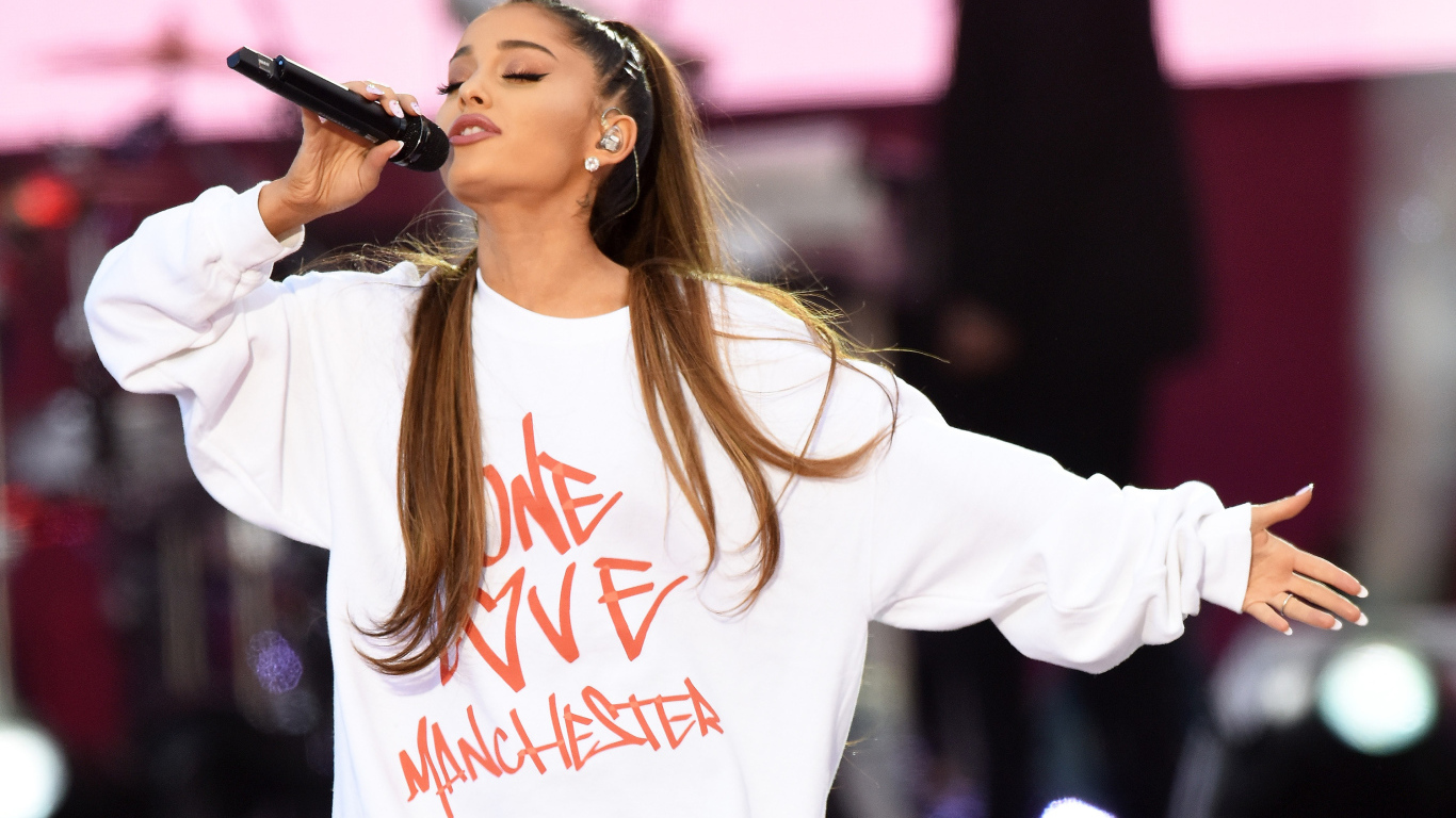 Молодая девушка, певица Ариана Гранде поет на сцене